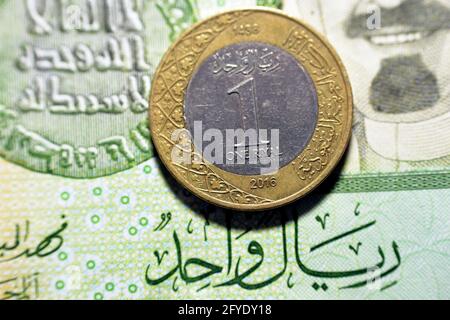 Eine Saudi-arabische Rial-Münze ( Rückseite ) Jahr 2016 auf einem Hintergrund mit 1 Saudi-riyal-Papierbanknote, eine Metall-Banknote und eine Saudi-riyale zusammen, Saudi riyals Stockfoto