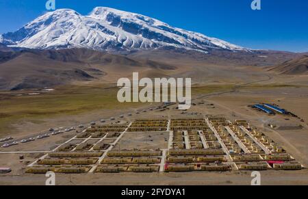 (210528) -- URUMQI, 28. Mai 2021 (Xinhua) -- Luftfoto vom 17. Mai 2021 zeigt eine Ansicht des Dorfes Subax am Fuße des Muztagh ATA im Bezirk Akto, nordwestlich der Autonomen Region Xinjiang Uygur in China. Bikmirza, ein 24-jähriger kirgisischer Hirte, wurde am Fuße des Muztagh ATA, einem Gipfel mit einer Höhe von mehr als 7,500 Metern, im Pamir der Autonomen Region Xinjiang Uygur in China geboren und aufgezogen. Im Alter von 18 Jahren begann er als Führer zu arbeiten, der Bergsteigern beim Tragen von Ausrüstung und Vorräten half. Das Besteigen von Muztagh ATA, einem Symbol für Tader, wird sogar als die Coming-of-Age-Zeremonie angesehen Stockfoto