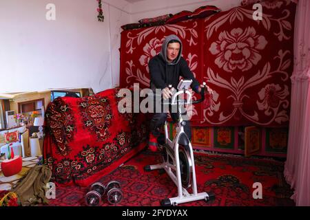 (210528) -- URUMQI, 28. Mai 2021 (Xinhua) -- Bikmirza Turdil übt zu Hause im Dorf Subax im Bezirk Akto, nordwestlich der Autonomen Region Xinjiang Uygur in China, 16. Mai 2021. Bikmirza, ein 24-jähriger kirgisischer Hirte, wurde am Fuße des Muztagh ATA, einem Gipfel mit einer Höhe von mehr als 7,500 Metern, im Pamir der Autonomen Region Xinjiang Uygur in China geboren und aufgezogen. Im Alter von 18 Jahren begann er als Führer zu arbeiten, der Bergsteigern beim Tragen von Ausrüstung und Vorräten half. Der Aufstieg zum Muztagh ATA, ein Symbol für Tapferei, gilt sogar als die Zeremonie der Alterseinkunft für einheimische Jugendliche. In Subax Stockfoto