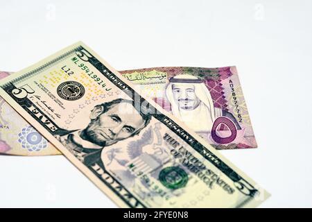 Selektiver Fokus auf US-Dollar-Schein und Saudi-arabische Riyals-Banknote mit 5 Saudi-Riyals, Saudi-arabischem Geld und US-Dollar-Akt Stockfoto