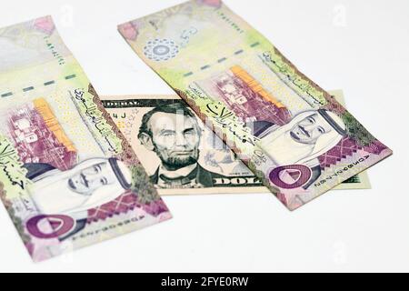Selektiver Fokus auf US-Dollar-Schein und Saudi-arabische Riyals-Banknote mit 5 Saudi-Riyals, Saudi-arabischem Geld und US-Dollar-Akt Stockfoto