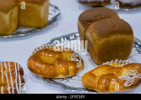 Frisch gebackenes Brot, Brezeln, Kringles auf dem Teller in der Bäckerei Stockfoto