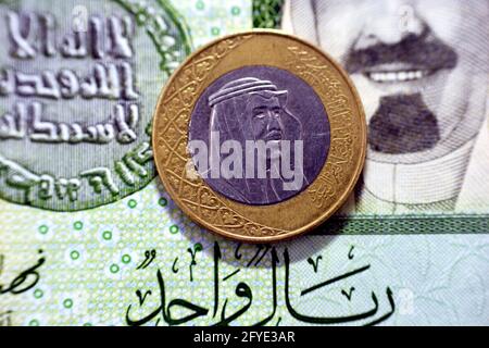 Eine Saudi-arabische Rial-Münze (obverse Seite), Jahr 2016 auf 1-Blatt-Banknotenhintergrund in saudischem Papier, eine Metall- und Banknotenausgabe Saudi-riyals zusammen, 1 Saudi-Arabien Stockfoto