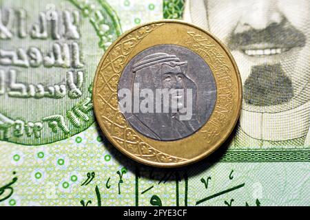 Eine Saudi-arabische Rial-Münze (obverse Seite), Jahr 2016 auf 1-Blatt-Banknotenhintergrund in saudischem Papier, eine Metall- und Banknotenausgabe Saudi-riyals zusammen, 1 Saudi-Arabien Stockfoto