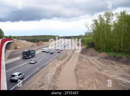 Velten, Deutschland. Mai 2021. Kurz nach der Kreuzung Oranienburg neben der im Bau befindlichen Fahrbahn fahren Autos und Lastwagen auf der verengten vierspurigen Fahrbahn der Autobahn A10 (Berliner Ring). Die A10 und die A24 zwischen dem Autobahnkreuz Pankow und dem Knotenpunkt Neuruppin gehören zu den verkehrsreichsten Strecken in der Hauptstadtregion. Sie werden bis 2022 modernisiert und erneuert, während der Verkehr weiter fließt. Quelle: Soeren Stache/dpa-Zentralbild/dpa/Alamy Live News Stockfoto