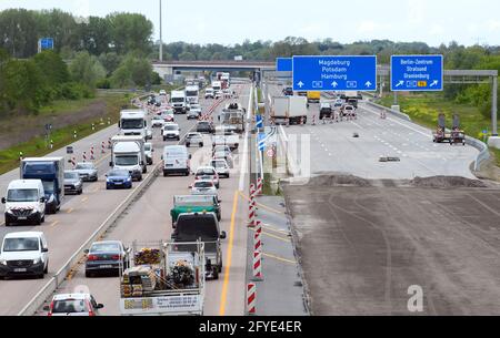 Velten, Deutschland. Mai 2021. Kurz vor dem Autobahnkreuz Oranienburg neben der im Bau befindlichen Fahrbahn fahren Autos und Lastwagen auf der verengten vierspurigen Fahrbahn der Autobahn A10 (Berliner Ring). Die A10 und die A24 zwischen dem Autobahnkreuz Pankow und dem Knotenpunkt Neuruppin gehören zu den verkehrsreichsten Strecken in der Hauptstadtregion. Sie werden bis 2022 modernisiert und erneuert, während der Verkehr weiter fließt. Quelle: Soeren Stache/dpa-Zentralbild/dpa/Alamy Live News Stockfoto