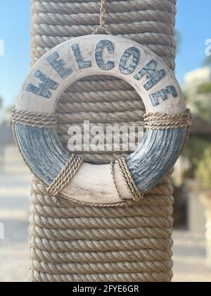 Vertikale Aufnahme einer blauen dekorativen Rettungsboje mit dem Text „Welcome“ Stockfoto