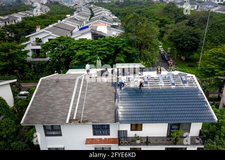 Eco-Park Wohngebiet, Provinz Hung Yen, Vietnam - 27. April 2021: Bauarbeiter bauen ein Ziegeldach für eine Villa im Eco-Park Residentya Stockfoto