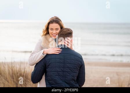 Junge schöne stilvolle Paar im Frühjahr am Strand. Umarmen Sie sich und genießen Sie einen warmen Frühlingsabend.Nahaufnahme. Stockfoto