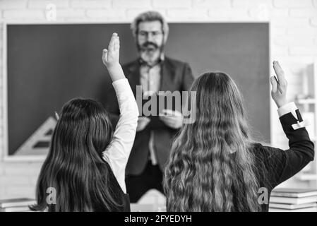 ich kenne die Antwort. Kleine Schüler studieren und Lesen. Hausaufgaben schreiben und lesen. Kinder Mädchen und Lehrer Mann. Grundschullehrer Stockfoto