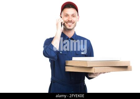 Horizontales mittleres Porträt eines gutaussehenden jungen kaukasischen Pizza-Typen mit Boxen, die am Telefon sprechen und auf die Kamera blicken, weißer Hintergrund Stockfoto