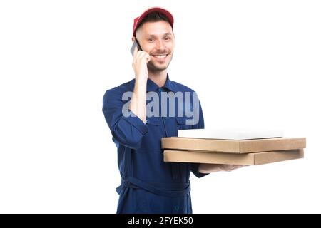 Horizontales mittleres Porträt eines gutaussehenden jungen kaukasischen Pizza-Typen mit Boxen, die am Telefon sprechen und auf die Kamera blicken, weißer Hintergrund Stockfoto