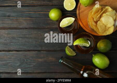 Bier mit Kalk und Chips auf Holzhintergrund Stockfoto