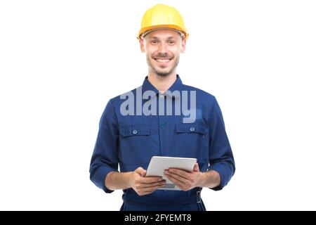 Horizontales mittleres Porträt des erfolgreichen hübschen jungen erwachsenen kaukasischen Bauingenieurs, der Uniform mit digitalem Tablet trägt, weißer Hintergrund Stockfoto