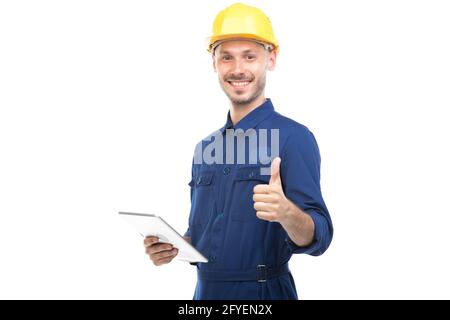Horizontales mittleres Porträt des erfolgreichen hübschen jungen erwachsenen kaukasischen Bauingenieurs, der Uniform mit digitalem Tablet trägt, weißer Hintergrund Stockfoto