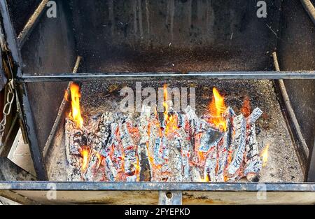 Feuer in einem alten rustikalen Metallrauchhaus. Stockfoto