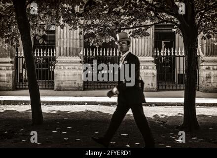 FRANKREICH. PARIS (75). EIN MANN MIT TOP-HUT UND BEIM SPAZIERGANG IM GARTEN DES PALAIS ROYAL'S Stockfoto