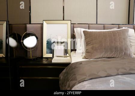 Einige weiße und braune Samtkissen auf dem Bett passen dazu Mit beigefarbenem Schlafzimmerton Stockfoto