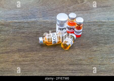 Flaschenimpfstoff des HPV-Impfstoffes (Human Papillomavirus) auf Holzgrund Stockfoto