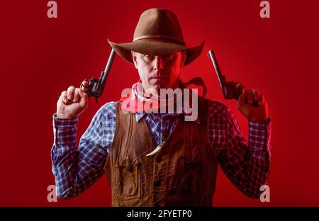 Mann mit Cowboyhut, Pistole. Porträt eines Cowboys. West, Waffen. Porträt eines Cowboys. Westlicher Mann mit Hut. Porträt eines Bauern oder Cowboys im Hut Stockfoto