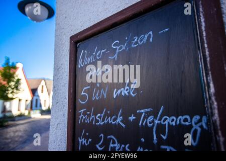 28. Mai 2021, Mecklenburg-Vorpommern, Warnemünde: Top-Winterpreise für fünf Nächte werden auf einer Tafel vor einem kleinen Hotel in der Altstadt von Warnemünde ausgeschrieben. Für Urlauber aus Mecklenburg-Vorpommern können Hotels und Ferienwohnungen wieder eröffnet werden. Foto: Jens Büttner/dpa-Zentralbild/dpa Stockfoto