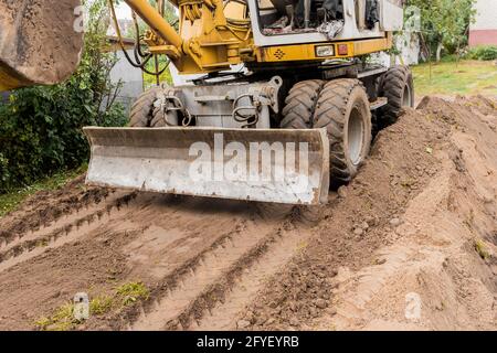 Bagger oder Bulldozer Schaufel flacht den Boden oder Straße in der Industriezone oder Baustelle. Stockfoto