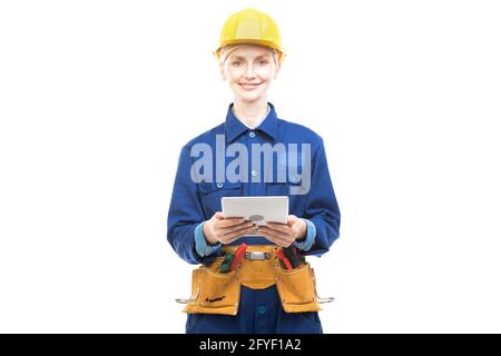 Horizontales mittleres Porträt einer modernen professionellen Bauarbeiterin in blauer Uniform mit digitalem Tablet, weißer Hintergrund Stockfoto
