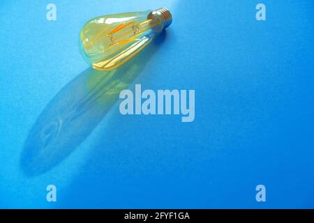 Eine Glühlampe auf blauem Papierhintergrund Stockfoto
