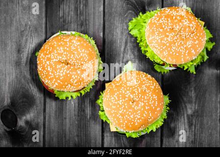 Klassische Hamburger, flach von oben auf schwarzes Brett gelegt Stockfoto