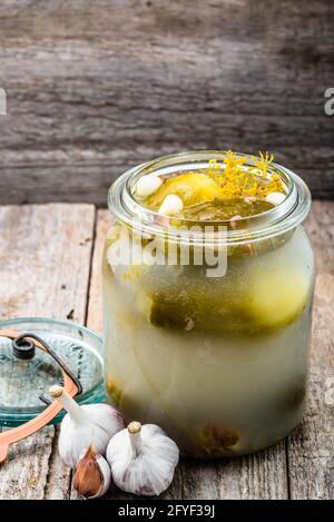 Eingelegte Gurken im Glas auf rustikalem Holztisch. Hausgemachte Gurkenkonserven. Stockfoto