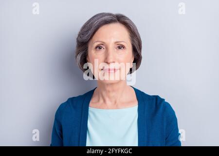 Porträt von schönen attraktiven Inhalt grauhaarige Frau trägt Strickjacke Isoliert auf grauem pastellfarbenem Hintergrund Stockfoto