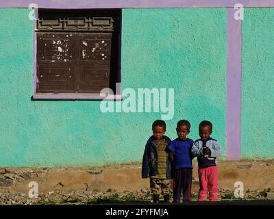 Drei äthiopische Kinder, kleine Jungen, stehen vor einem bunten Haus im Dorf Atsbi, Tigray, Äthiopien Stockfoto