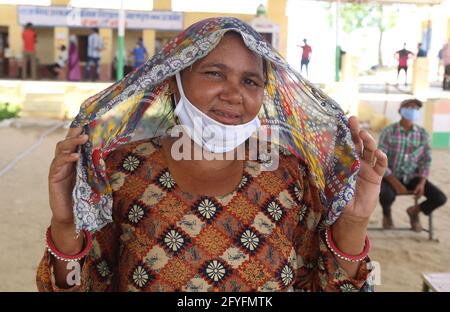 Beawar, Rajasthan, Indien, 27. Mai 2021: Ländliche Frau lächelt, nachdem sie ihre erste Dosis COVID-19-Impfstoff in einem Impfzentrum im Dorf Malpura in der Nähe von Beawar erhalten hat. Indiens anhaltende und verheerende Welle von Covid-19-Infektionen hat die Städte erfasst und die städtischen Gesundheitsressourcen überfordert, aber sie hat auch tief in das ländliche Indien eingedrungen, wo das wahre Ausmaß der Verwüstung unbekannt ist, weil es an weit verbreiteten Tests oder zuverlässigen Daten fehlt. Kredit: Sumit-Samarwat/Alamy Live Nachrichten Stockfoto