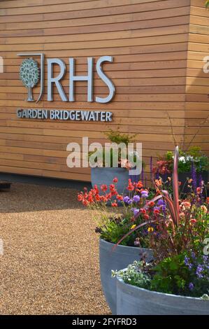 Farbenfrohe Blumendarstellung in Containern vor dem Eingang zum Welcome Building im RHS Garden Bridgewater, Worsley, Manchester, Großbritannien. Stockfoto