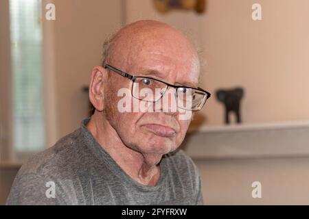 Ein alter kahler Mann mit Brille. Ein großes Porträt. Im Raum, Aufnahmen mit einem Frontalblitz. Stockfoto