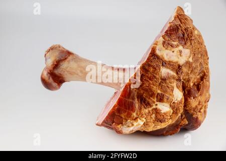 Geräucherter Knochen in Schinken auf weißem, isoliertem Hintergrund. Nahaufnahme. Stockfoto