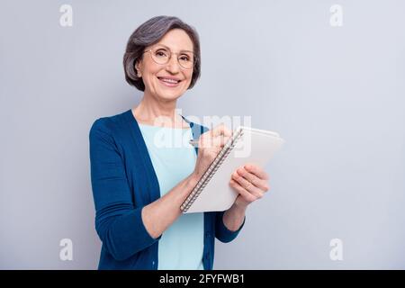 Bildportrait einer Geschäftsfrau mit Brille und Schreibhinweisen Mit Stift auf Interview isoliert auf grauem Hintergrund Stockfoto