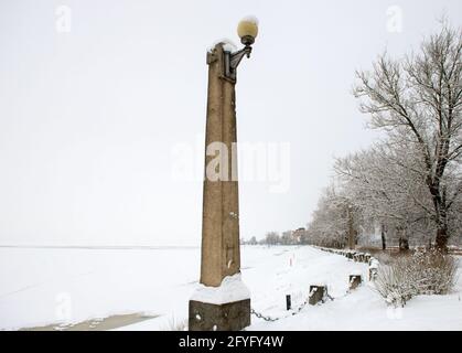 Eine Säule mit einer Laterne am Ufer des Stausee an einem frostigen Wintertag Stockfoto