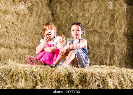 Bayerische Mädchen sitzen auf Heuboden mit Brezeln Stockfoto