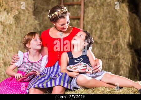 Bayerischen Familie sitzt am Heuboden mit Lebkuchen Stockfoto