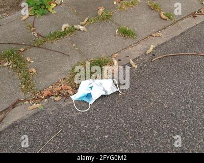 Gesichtsmaske auf der Straße ist Koronavirus-bedingte Vermüllung Stockfoto