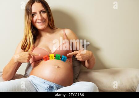 Schwanger Frau zeigen Mädchen Wort auf Bauch Stockfoto