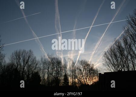 Klarer Morgenhimmel mit mehreren Kontrasten, weiße Linien am Himmel, die von Flugzeugen hinterlassen werden Stockfoto