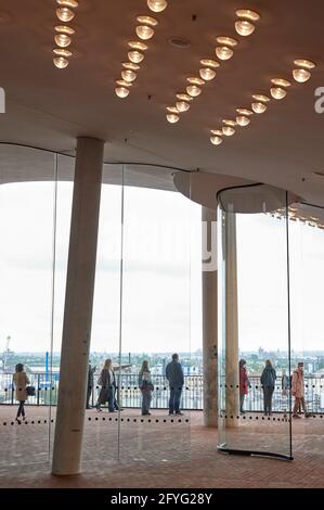 Hamburg, Deutschland. Mai 2021. Besucher gehen hinter die Glastüren auf der Elbphilharmonie Plaza. Die Elbphilharmonie Plaza wurde nach einer Pause wegen Corona wieder eröffnet. Quelle: Georg Wendt/dpa/Alamy Live News Stockfoto