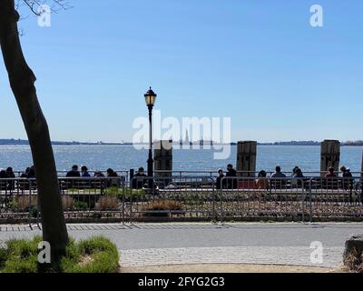 New York, NY, USA - 28. Mai 2021: Menschen entspannen auf Bänken im Battery Park Stockfoto