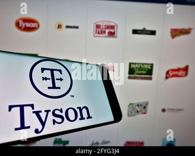 Handy mit Logo des US-Lebensmittelverarbeitungsunternehmens Tyson Foods Inc. Auf dem Bildschirm vor der Business-Webseite. Konzentrieren Sie sich auf die Mitte rechts des Telefondisplays. Stockfoto