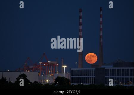 Wunderschöne Aussicht auf rote Superblumen der Mond steigt am irischen Himmel zwischen den berühmten Schornsteinen der Poolbeg Generating Station (Poolbeg CCGT) am 26. Mai 2021 auf f Stockfoto