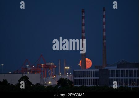 Wunderschöne Aussicht auf rote Superblumen der Mond steigt am irischen Himmel zwischen den berühmten Schornsteinen der Poolbeg Generating Station (Poolbeg CCGT) am 26. Mai 2021 auf f Stockfoto