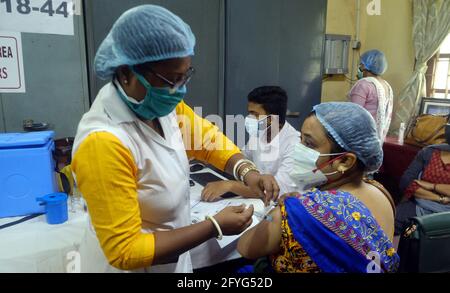 Kalkutta, Indien. Mai 2021. Eine Grundschullehrerin erhält am 28. Mai 2021 von einem Gesundheitshelfer an einer Schule in Kalkutta, Indien, einen COVID-19-Impfstoff. Quelle: Str/Xinhua/Alamy Live News Stockfoto