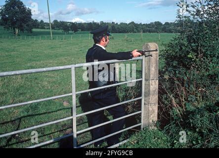 COUNTY TYRONE, VEREINIGTES KÖNIGREICH - SEPTEMBER 1980. RUC, Royal Ulster Constabulary, Polizei auf Fahrzeug halten und suchen während der Unruhen, Nordirland, 1980er Jahre Stockfoto